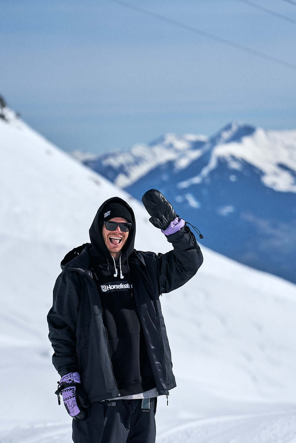 Snowboarder wearing The Team Transform x Glitterstudio Lavender mitten on a snowy mountain.