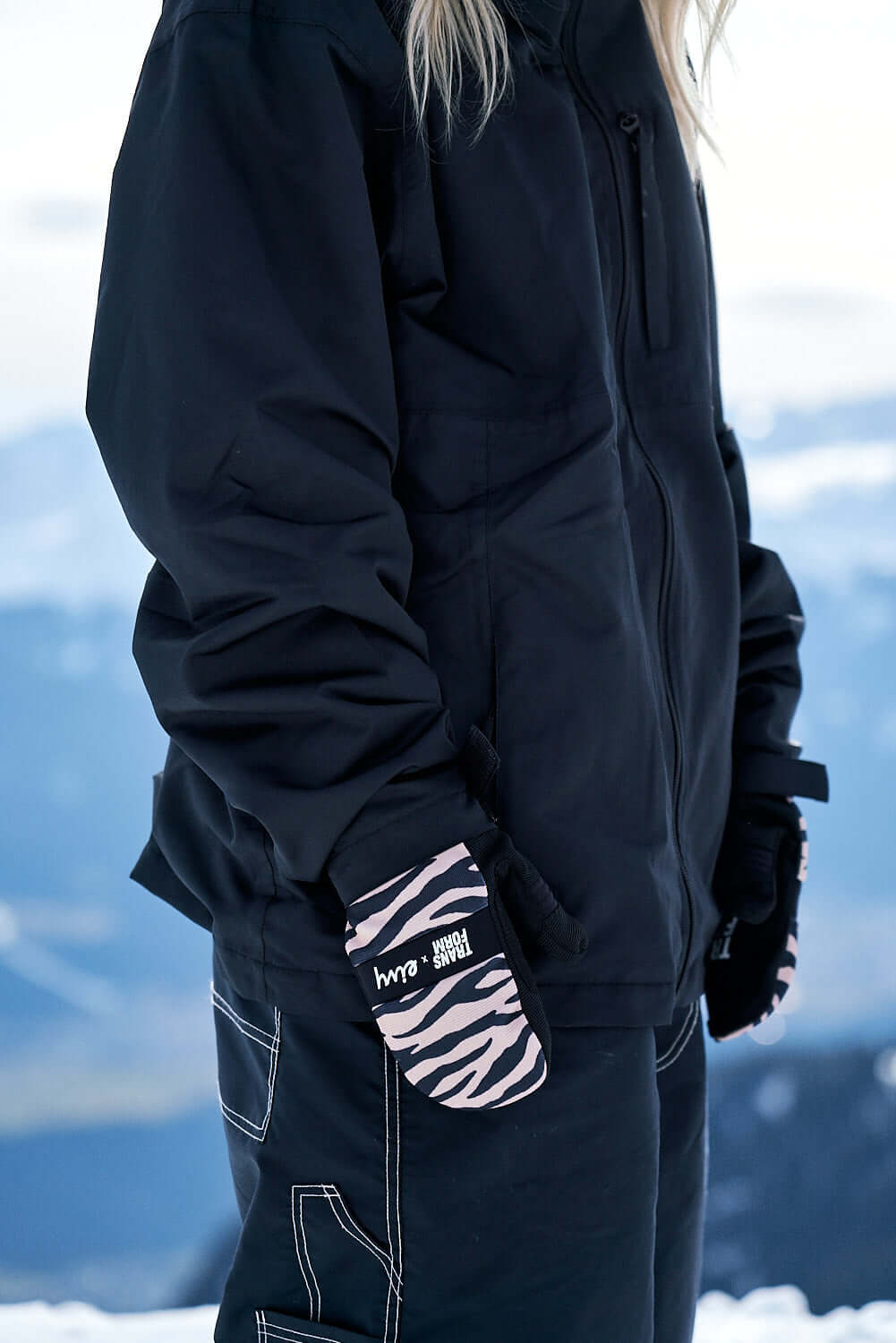 snowboard mittens with zebra pattern in a snowy mountain backdrop.