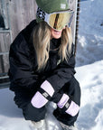 The Spring Mitt Pink mittens while snowboarding on a sunny day.