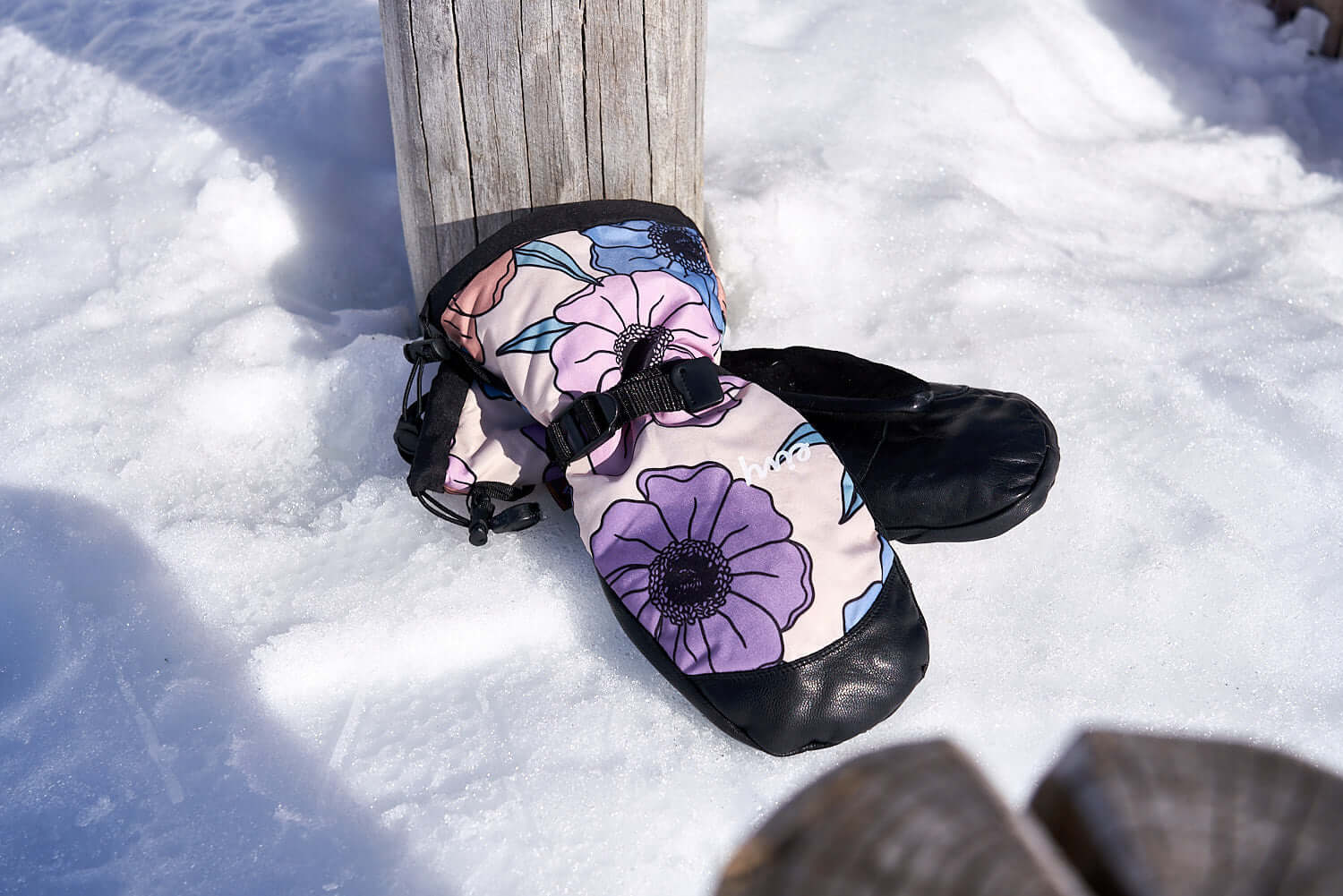 The Team Transform x Eivy Big Flower snowboard mittens on snow with vibrant floral design, Primaloft insulation, and Hipora waterproof inserts.